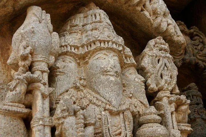 Nahaufnahme detaillierter Steinmetzarbeiten, die eine Figur an einem Tempel zeigen